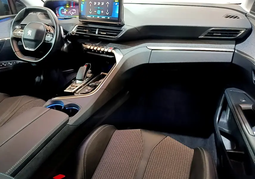 Intérieur noir du Peugeot 3008 hybride, vue côté passager avec tableau de bord et écran tactile central visible.