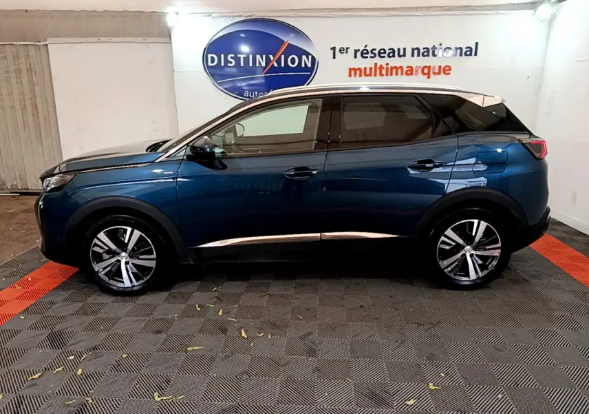 Profil côté gauche du Peugeot 3008 hybride rechargeable bleu, avec jantes alliage et toit noir en intérieur showroom.