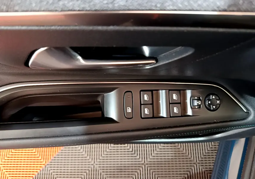 Vue rapprochée des commandes des vitres et rétroviseurs sur la porte côté conducteur du Peugeot 3008 bleu hybride rechargeable.