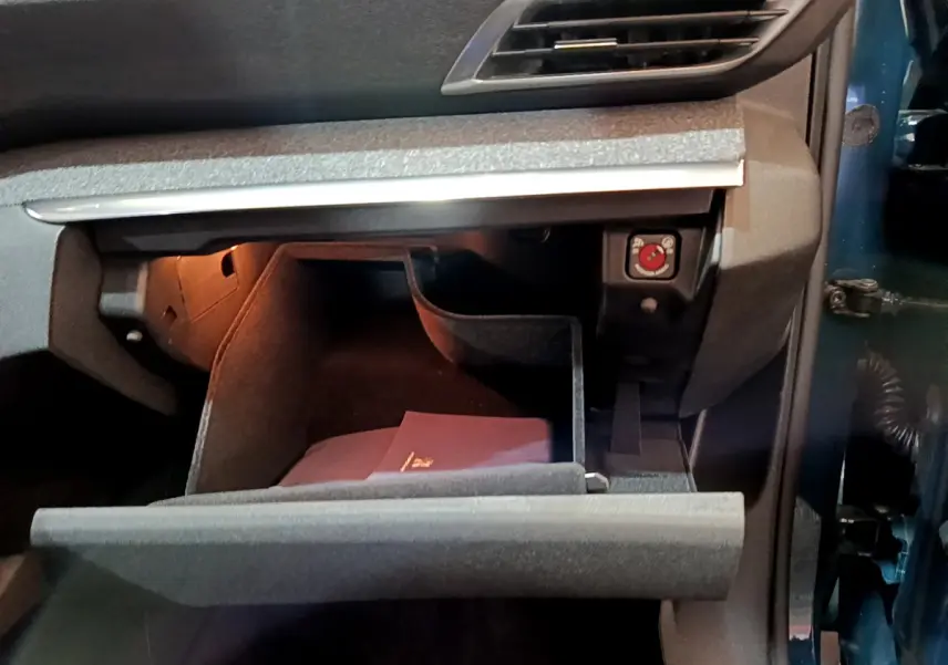 Vue rapprochée de la boîte à gants ouverte côté passager du Peugeot 3008 bleu hybride rechargeable 2021.