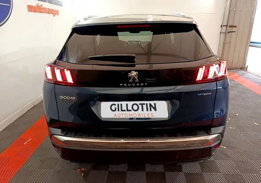 Vue arrière du Peugeot 3008 hybride rechargeable bleu avec feux arrière LED allumés et logo visible sur hayon noir.