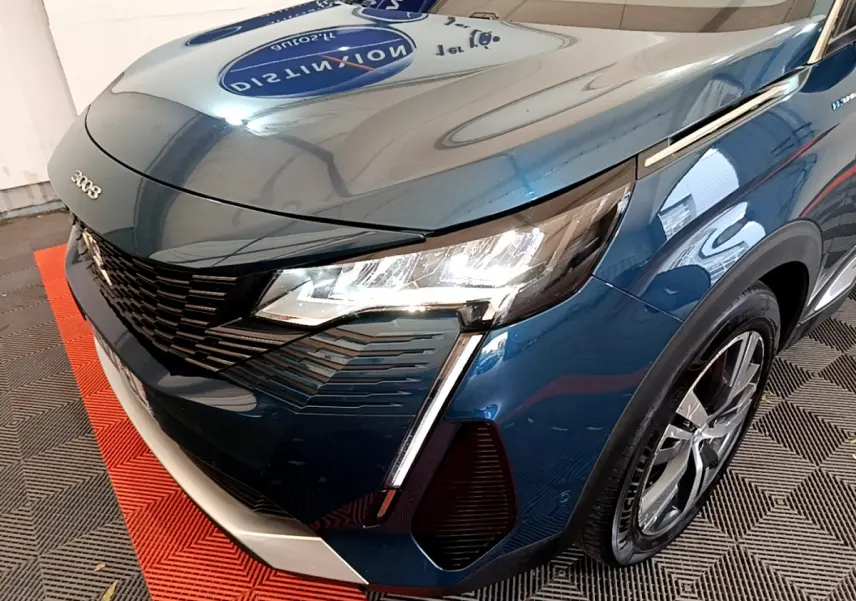 Vue 3/4 avant droit d'un Peugeot 3008 hybride rechargeable bleu avec phares LED et calandre noire distinctive.