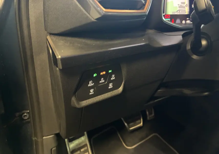 Vue intérieure côté gauche du tableau de bord noir avec commandes d'éclairage et pédales visibles dans une CUPRA Formentor 2023.