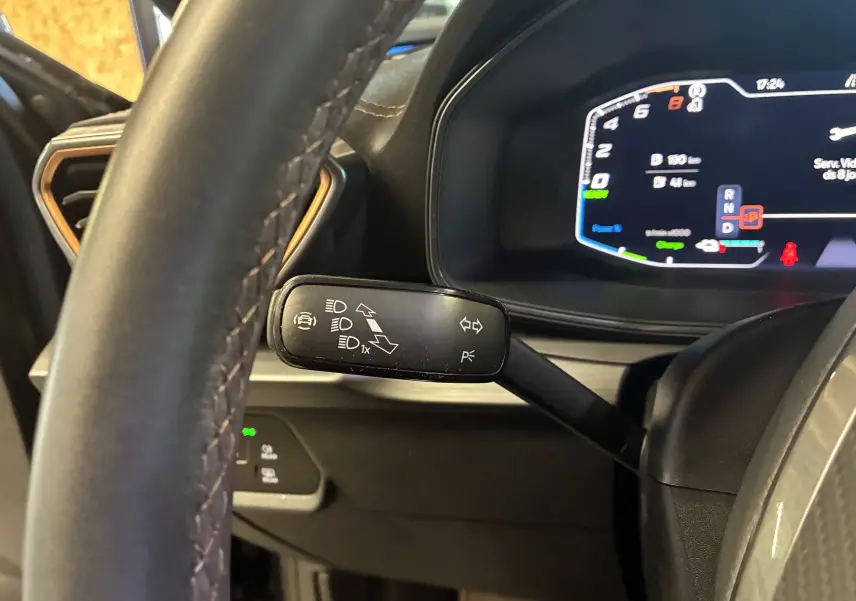 Vue rapprochée du commodo gauche noir avec pictogrammes, volant cuir noir et tableau de bord digital du CUPRA Formentor bleu.