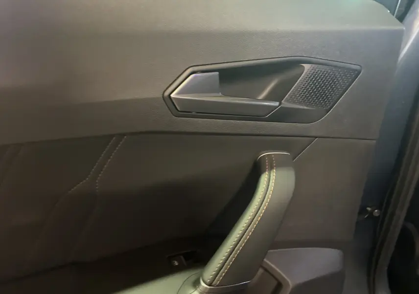 Poignée de porte intérieure côté gauche en similicuir noir avec surpiqûres cuivre sur CUPRA Formentor 2023.