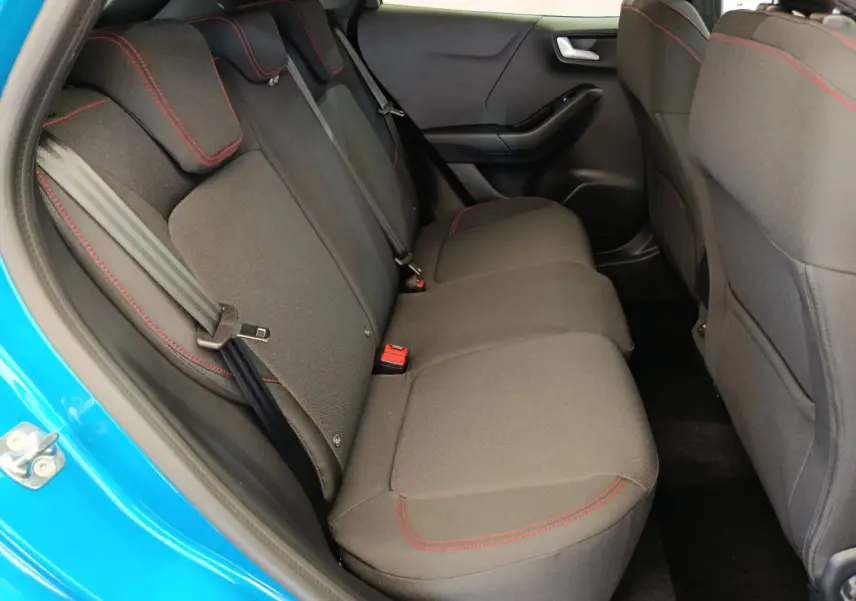 Vue intérieure côté gauche sur la banquette arrière noire avec surpiqûres rouges du Ford Puma bleu 2025 ST-LINE.