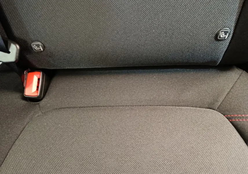 Gros plan sur la banquette arrière noire du Ford Puma 2025 avec fixation Isofix et ceinture rouge visible.