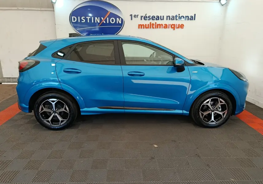 Ford Puma 2025 bleu en profil côté gauche, avec jantes alliage noires et logo ST-LINE visible sur l'aile avant.