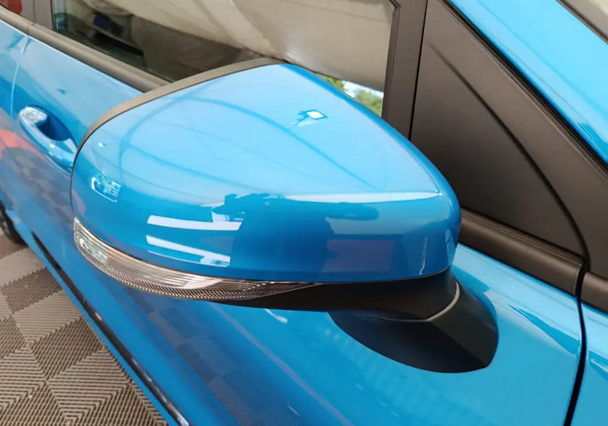 Rétroviseur côté gauche bleu vif du Ford Puma 2025 avec clignotant intégré, vue rapprochée sur la portière.