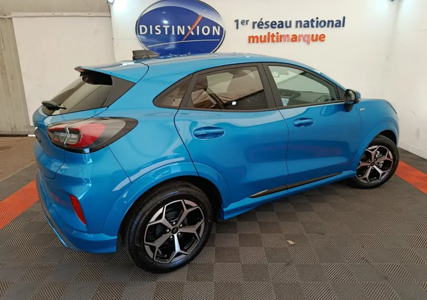 Vue 3/4 arrière droite du Ford Puma bleu ST-LINE 2025 avec jantes alliage et vitres teintées en showroom.