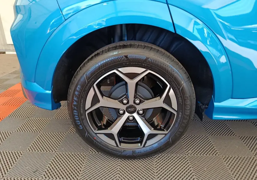 Gros plan sur la roue avant gauche du Ford Puma bleu 2025 avec jante alliage noire et argentée design moderne.