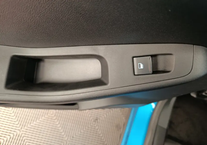 Gros plan sur la poignée intérieure de porte côté conducteur du Ford Puma bleu 2025 avec bouton de verrouillage.