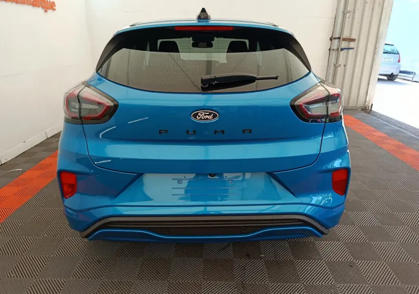 Vue arrière d'un Ford Puma bleu 2025 avec feux LED et logo Ford bien visibles sur un sol à damiers.