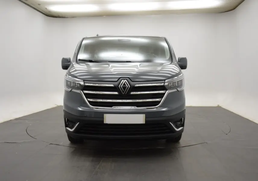 Vue frontale du Renault Trafic Fourgon gris clair 2025 avec calandre chromée et phares LED ellipsoïdaux.