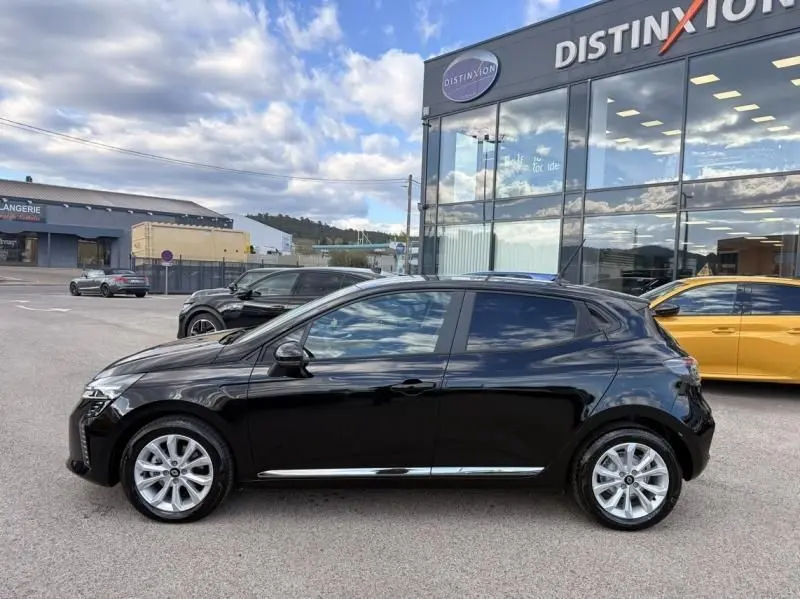 Profil côté gauche de la Renault Clio V noire 2025, version 1.5 DCI 100 Evolution, garée devant un showroom Distinxion.