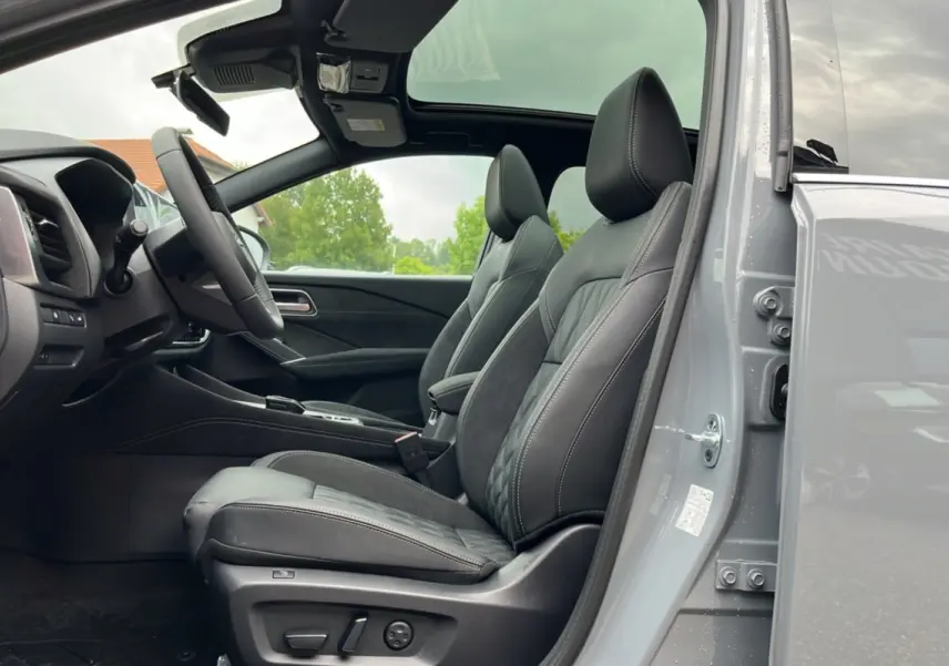 Vue intérieure côté gauche du Nissan Qashqai E-POWER 205 Tekna Plus 2026, sièges cuir noirs et toit panoramique ouvert.
