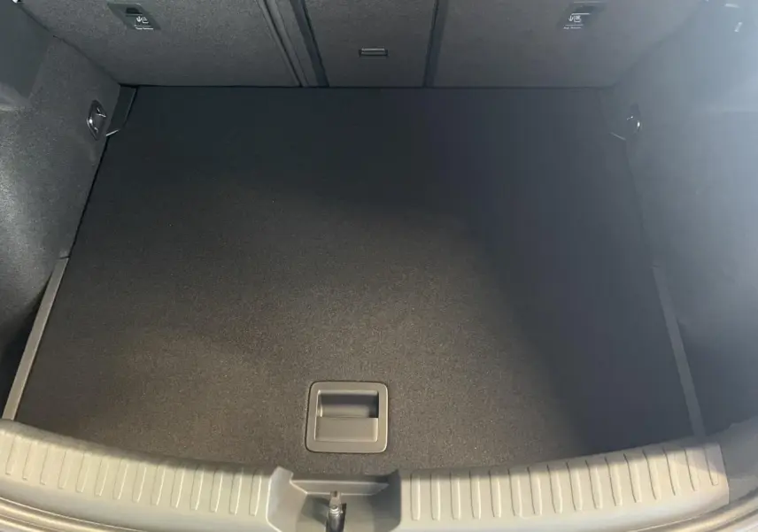 Coffre ouvert vu de dessus d'une CUPRA Leon gris, montrant un espace de chargement propre et vide.