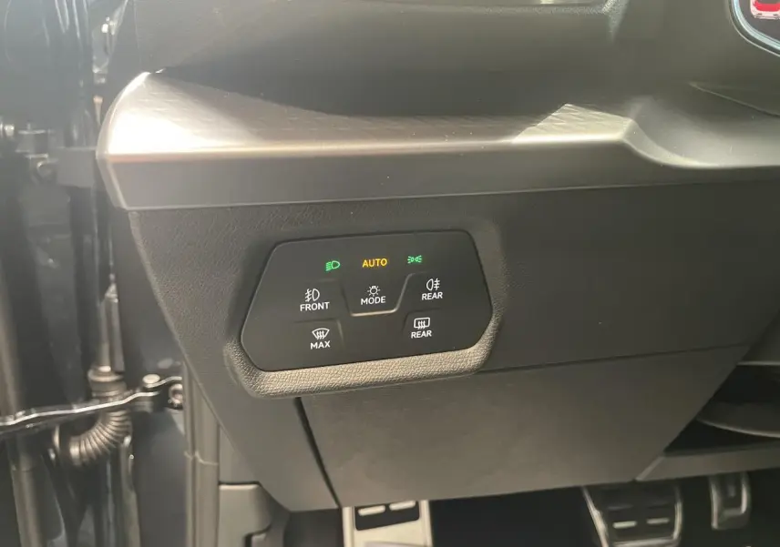 Gros plan sur le panneau de commande des feux automatiques dans l’habitacle d’une CUPRA Leon gris.