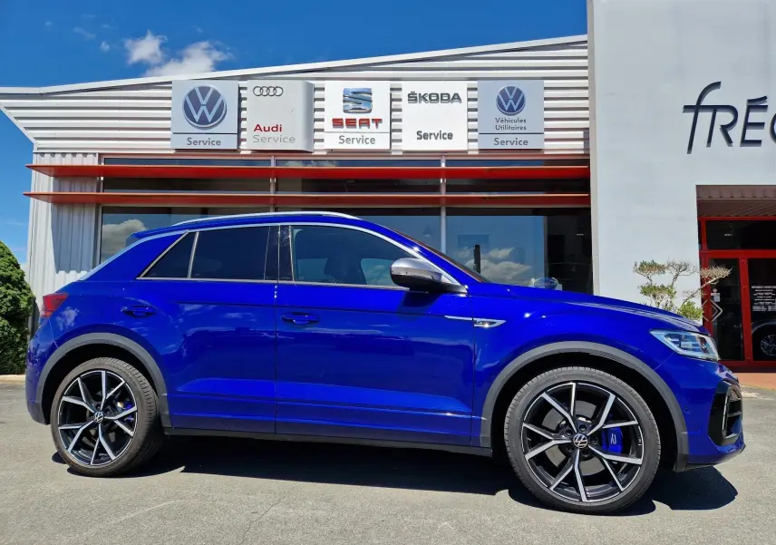 Profil droit du Volkswagen T-Roc 2.0 TSI 300 R bleu Lapiz avec jantes alliage noires et étriers bleus.