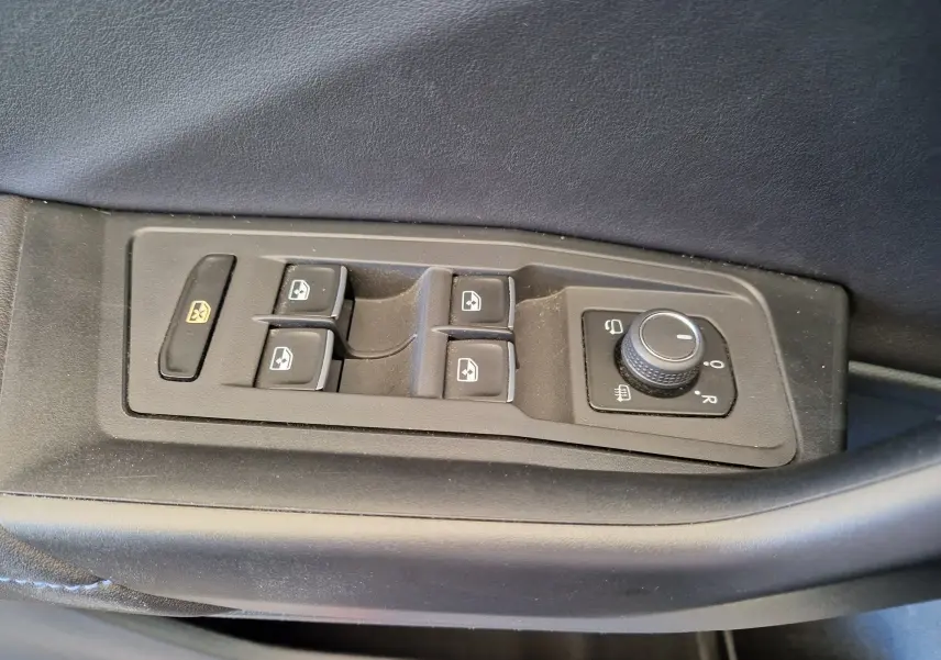 Panneau de commandes des vitres et rétroviseurs côté conducteur du Volkswagen T-Roc bleu Lapiz 2022, intérieur noir.