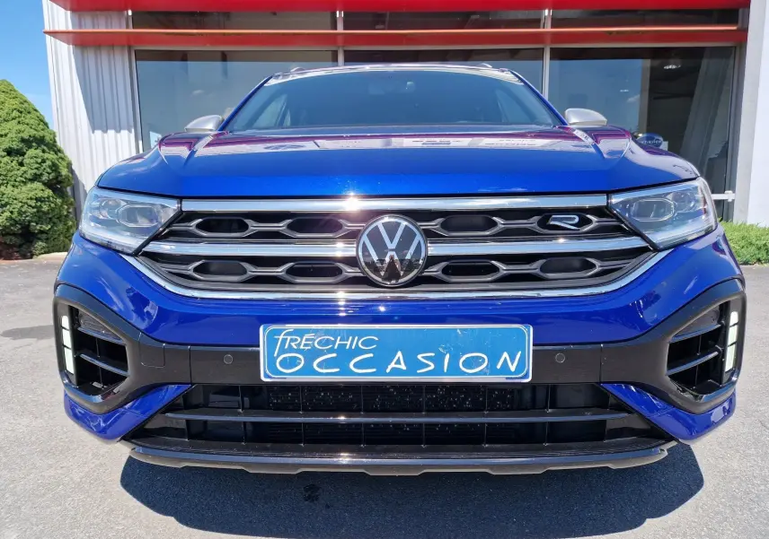 Vue frontale rapprochée du Volkswagen T-Roc R 2022 en bleu Lapiz avec calandre chromée et plaque d'occasion bleue.