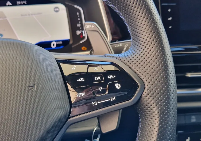 Gros plan sur le volant en cuir perforé du Volkswagen T-Roc 2022, avec commandes multifonctions côté gauche.