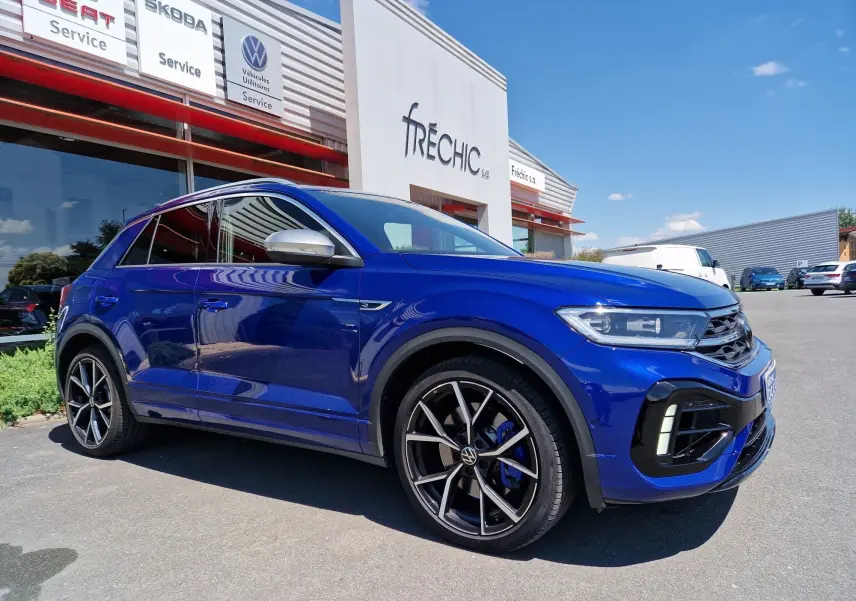 Volkswagen T-Roc bleu Lapiz en 3/4 avant droit, avec jantes noires et étriers de frein bleus visibles.