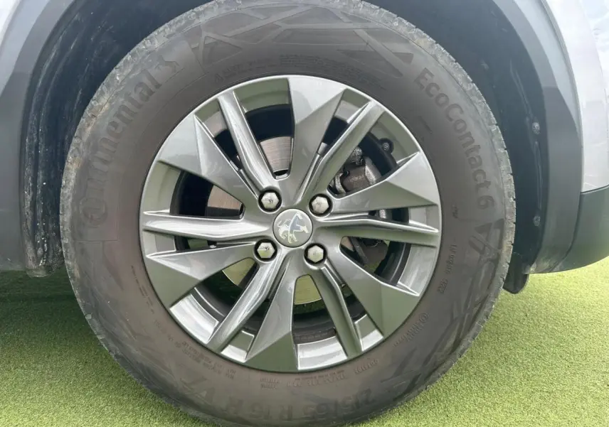 Gros plan sur la roue avant gauche du Peugeot 2008 gris clair avec jante alliage 16'' Elborn.