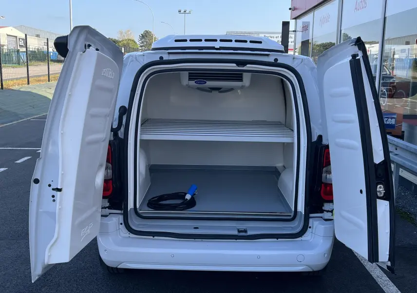 Vue arrière du Toyota Proace City blanc glacier 2023 avec portes ouvertes et compartiment frigorifique visible.
