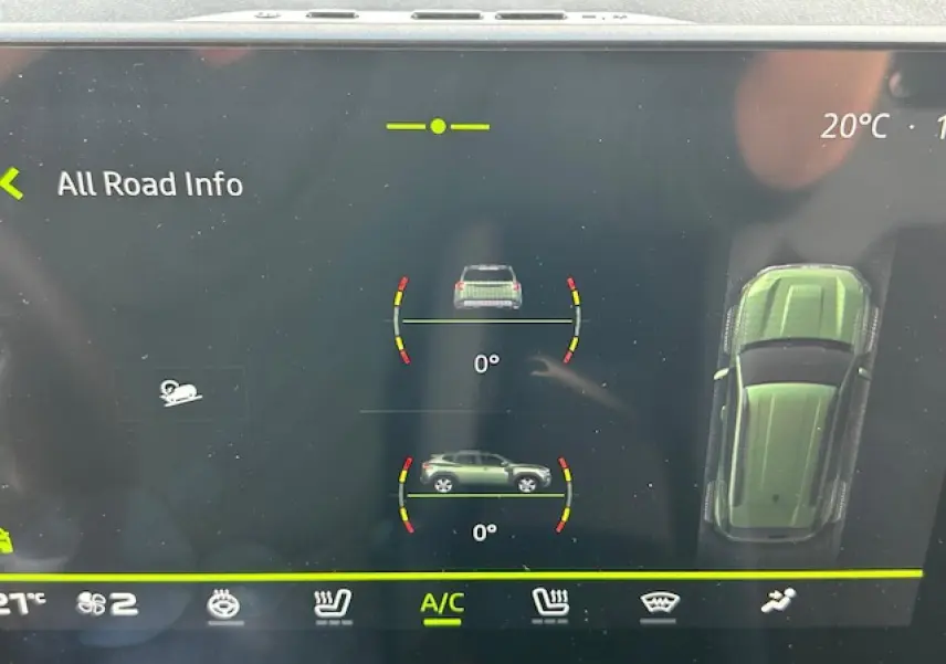 Écran digital du tableau de bord du Dacia Duster 2025 affichant l'inclinaison et la vue aérienne du véhicule kaki dusty.