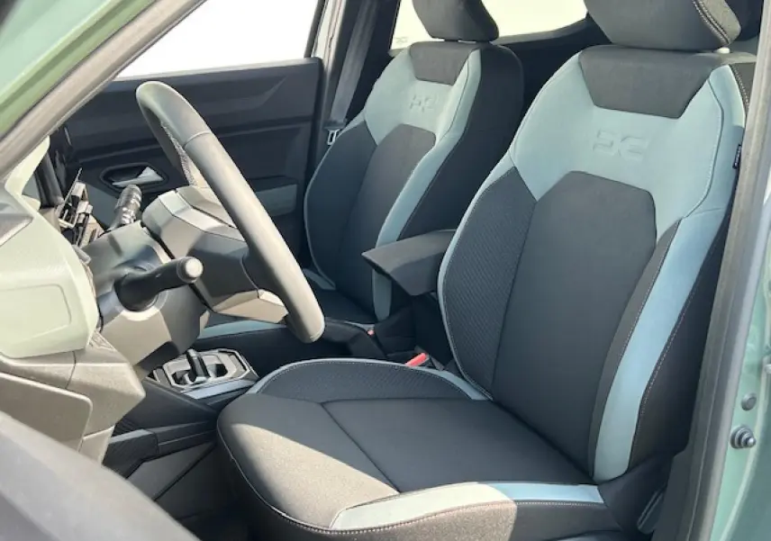Intérieur du Dacia Duster III 2025 en kaki lichen, vue côté conducteur sur sièges TEP MicroCloud et volant soft feel.