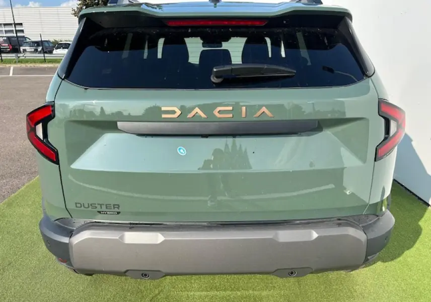 Vue arrière du Dacia Duster III 1.6 Hybrid 140 4x2 en kaki dusty avec logo doré et feux arrière en forme de C.