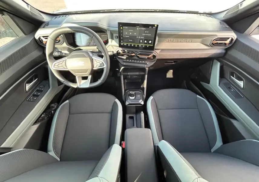 Vue intérieure avant du Dacia Duster III 1.6 Hybrid 140 avec tableau de bord digital et sellerie TEP MicroCloud kaki lichen.