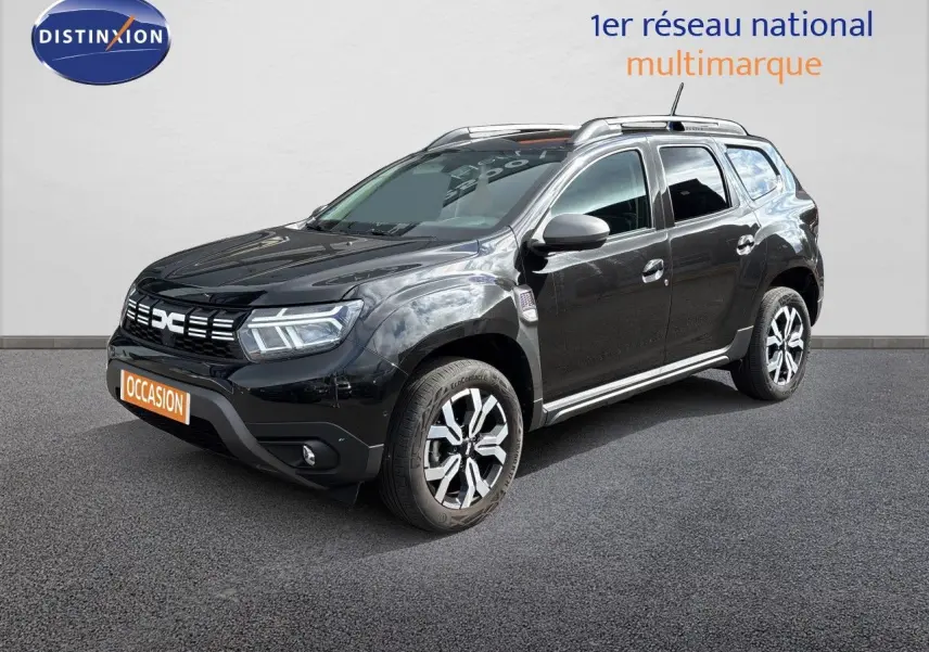 Dacia Duster noir en 3/4 avant droit, mettant en valeur ses jantes bicolores et sa calandre distinctive.