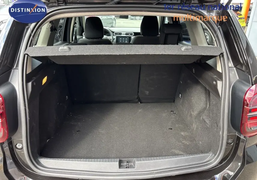 Coffre ouvert du Dacia Duster noir 2024, vue arrière montrant l'espace de chargement et l'intérieur des sièges arrière.