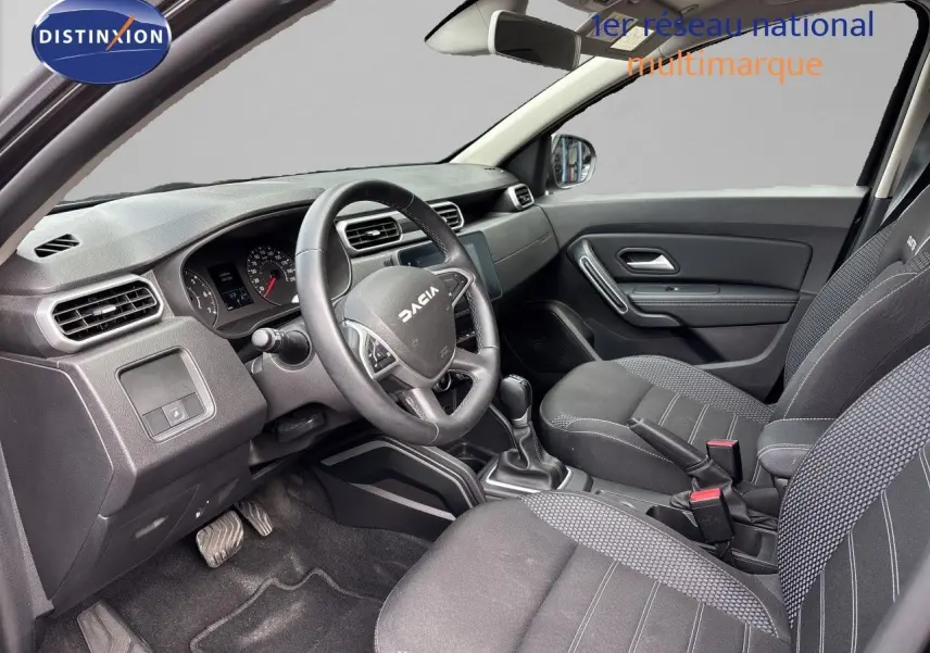 Vue intérieure avant du tableau de bord et volant noir du Dacia Duster Journey TCe 150 EDC 2024 avec écran tactile central.