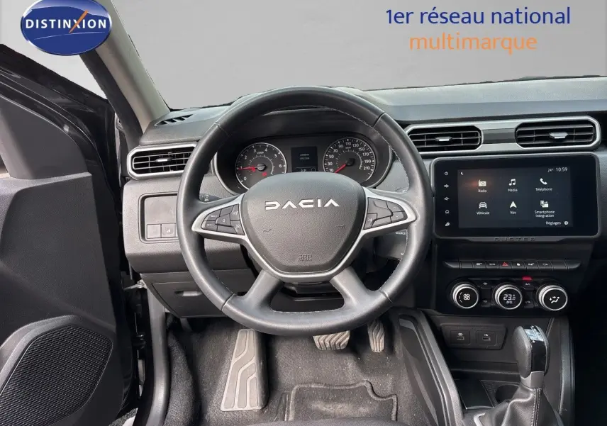 Vue intérieure centrée sur le volant et tableau de bord du Dacia Duster noir 2024 avec écran tactile et boîte automatique.