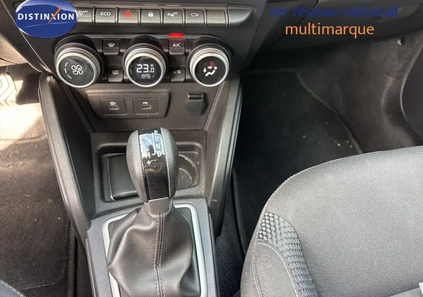 Gros plan sur la console centrale du Dacia Duster noir 2024, mettant en valeur le levier de vitesse automatique et les commandes de climatisation.