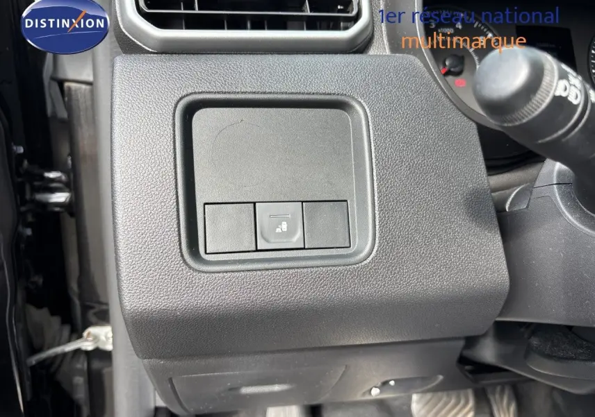 Gros plan sur le tableau de bord côté gauche d’un Dacia Duster noir 2024, montrant un bouton de commande.