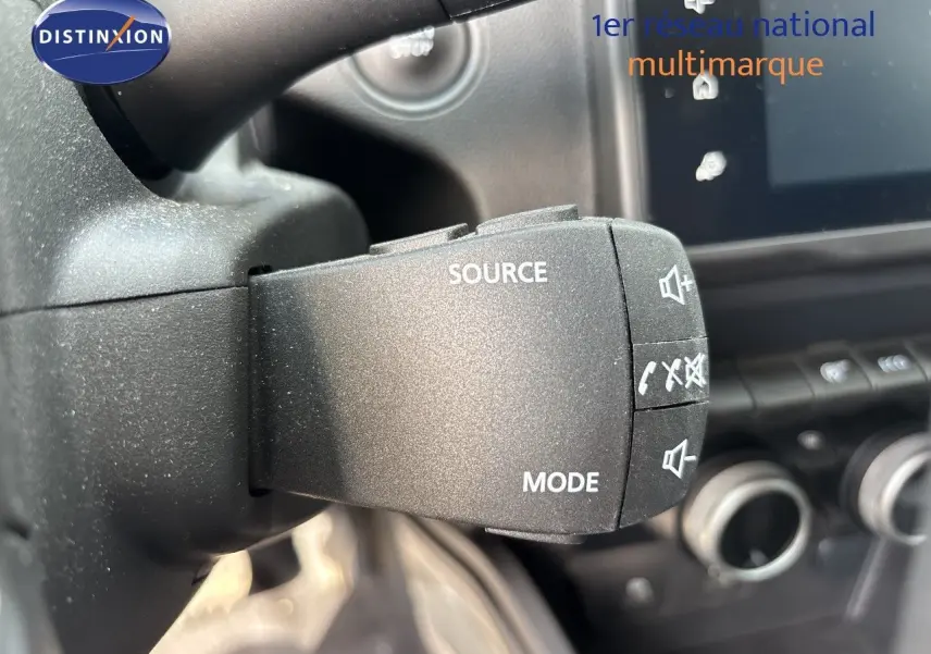 Gros plan sur la commande au volant du Dacia Duster 2024, mettant en valeur les boutons source et mode.
