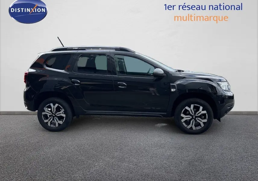 Profil côté gauche du Dacia Duster Journey TCe 150 EDC noir 2024 avec jantes bi-ton et toit équipé de barres de toit.