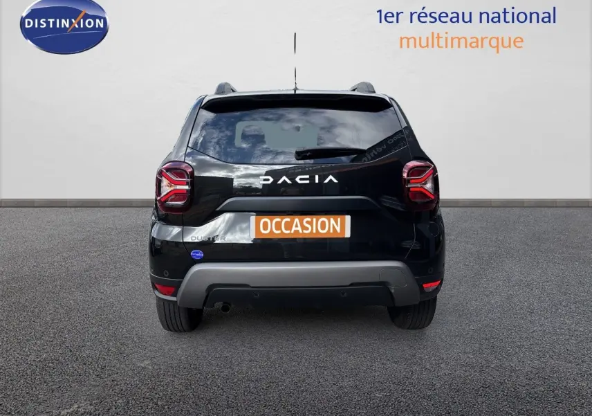Vue arrière d'un Dacia Duster noir 2024 avec logo et plaque "OCCASION" sur fond neutre.