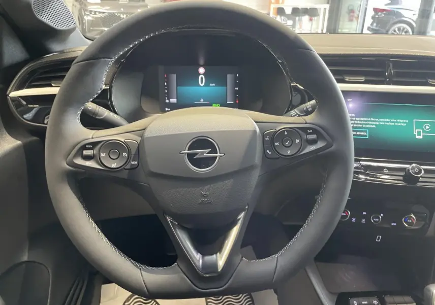 Vue intérieure centrée sur le volant noir de l'Opel Corsa 1.2 Turbo 2026 avec tableau de bord numérique et écran tactile.
