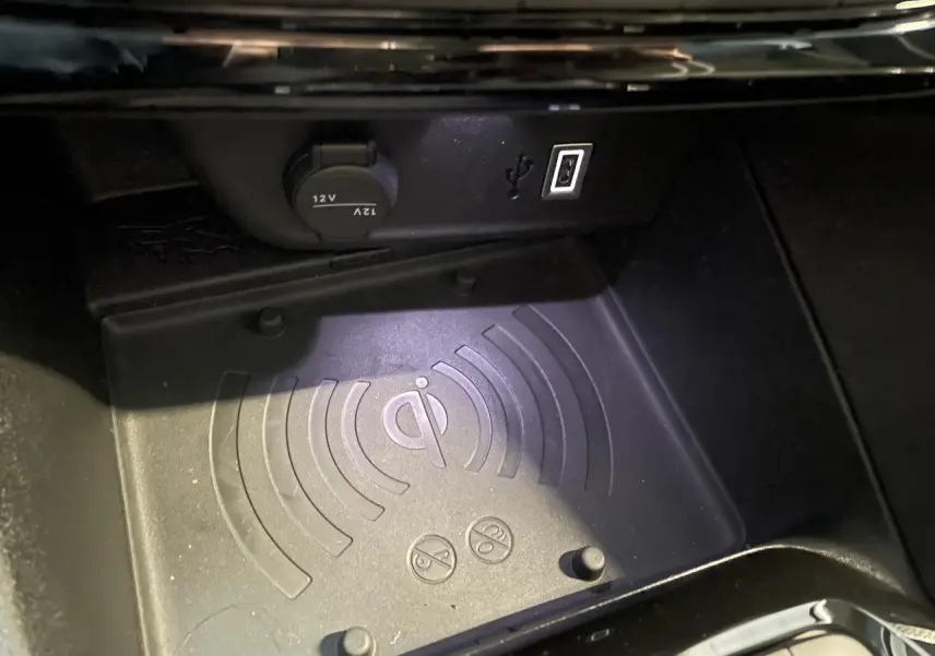 Gros plan sur le chargeur à induction et prises USB dans la console centrale de l’Opel Corsa blanche.
