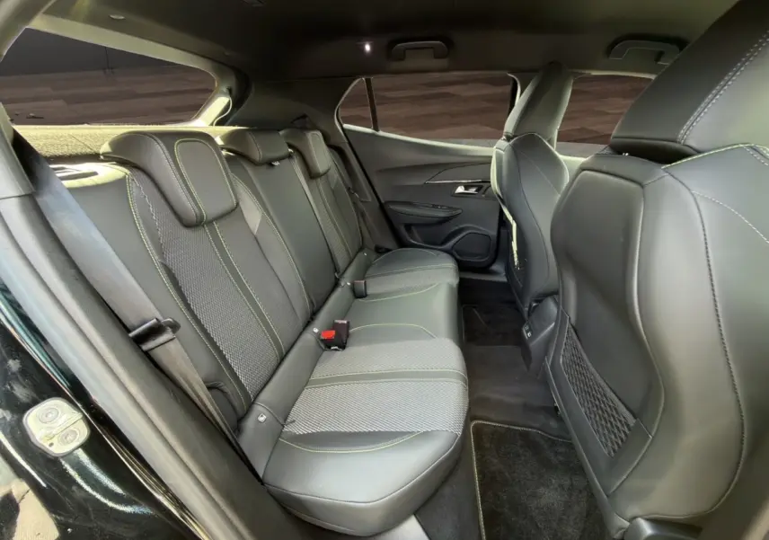 Vue intérieure côté gauche des sièges arrière en cuir noir avec surpiqûres vertes du Peugeot 2008 Hybrid 145 e-DCS6 GT 2026.