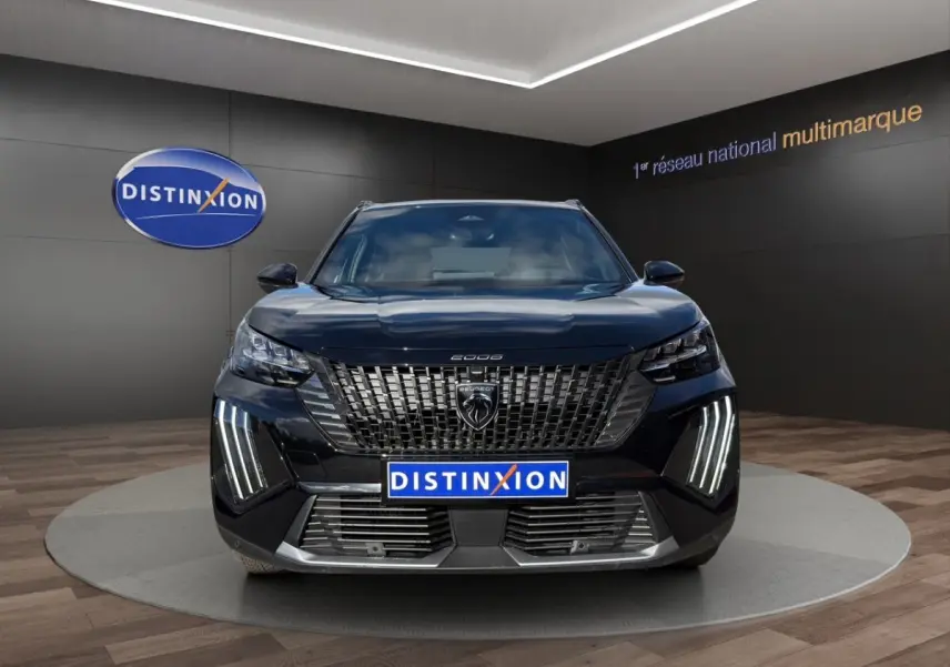 Vue frontale d’un Peugeot 2008 Hybrid 145 e-DCS6 GT noir avec calandre distinctive et feux LED verticaux allumés.