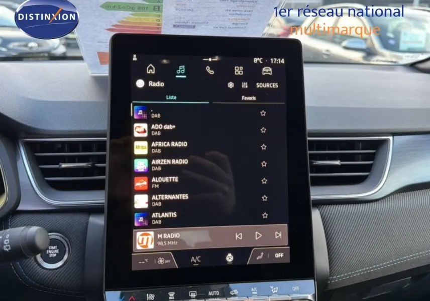 Vue intérieure centrée sur l'écran tactile multimédia du Renault Captur blanc nacré avec toit gris, tableau de bord moderne.