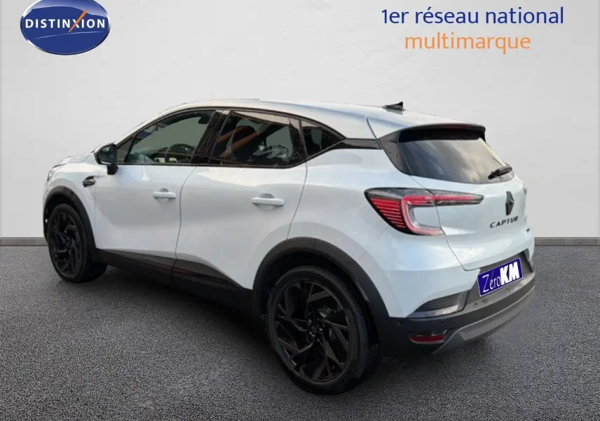 Vue 3/4 arrière droite du Renault Captur blanc nacré avec toit gris et jantes noires distinctives.