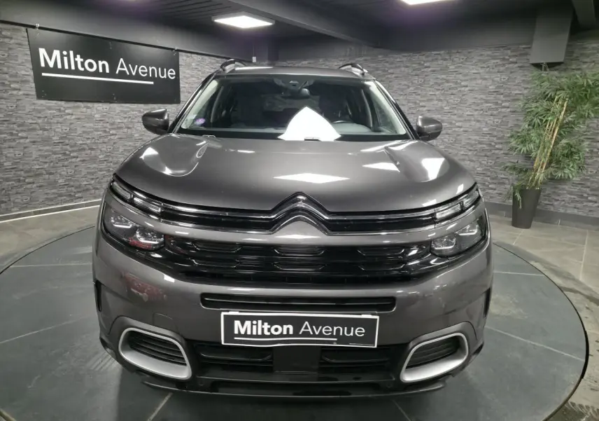 Vue frontale d'un Citroën C5 Aircross gris métallisé avec calandre noire brillante et détails chromés.