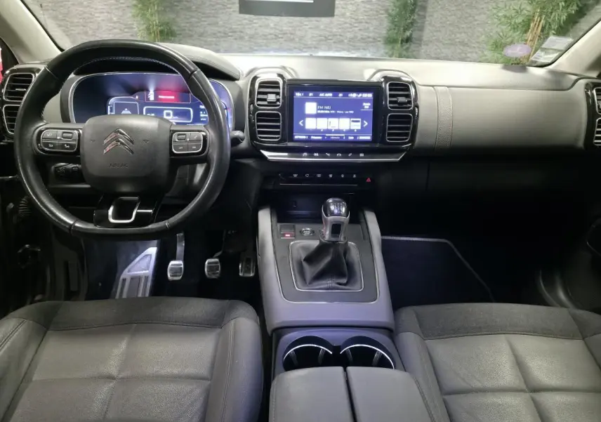 Intérieur du Citroën C5 Aircross 2019, vue du poste de conduite avec volant cuir et écran tactile central.